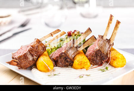 Garniert mit gestampften Kartoffeln gefüllte Kroketten Lamm Rack. Abendessen-Einstellungen. Stockfoto