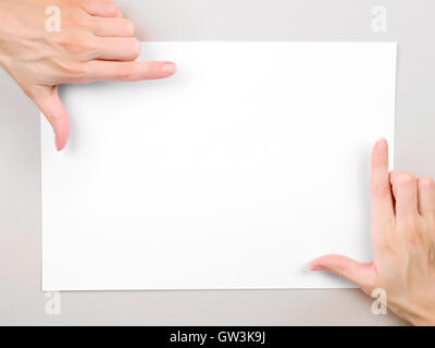 Frau Hände über leeres Papierblatt Rahmen. Vorlage mit Textfreiraum Stockfoto