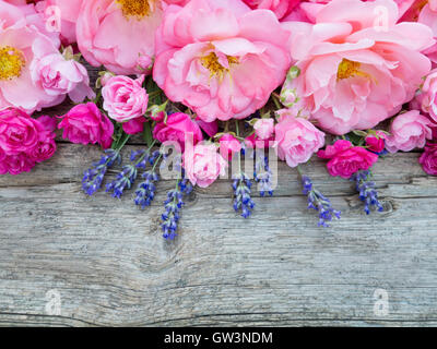 Rosa Rosen und Lavendel Haufen auf den grauen verwitterten Holzbrett Stockfoto