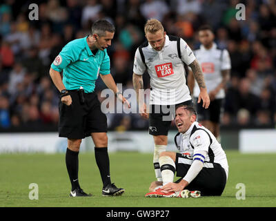 Schiedsrichter James Linington und Derby County Johnny Russell sprechen mit Teamkollege Richard Keogh (Stock), wie er zuckt vor Schmerz, nachdem eine Herausforderung von Newcastle United Mohamed Diame während der Himmel Bet Championship match bei der iPro-Stadion, Derby. Stockfoto