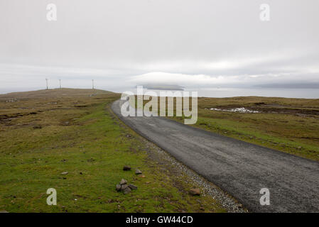 Straße auf den Färöer Inseln im Süden von Eysturoy mit Windmühlen und nolsoy Stockfoto