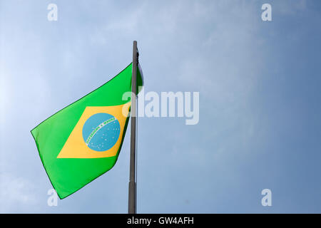 Nationalflagge von Brasilien auf einem Fahnenmast vor blauem Himmel Stockfoto