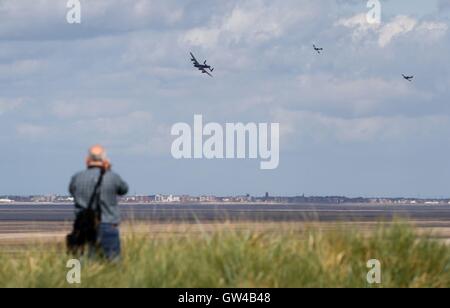 Die Schlacht of Britain Memorial Flight einschließlich einen Lancaster-Bomber, herabfliegen ein Spitfire und ein Hurrikan den Fluss Mersey in Richtung Southport, Southport Airshow teilnehmen. Stockfoto