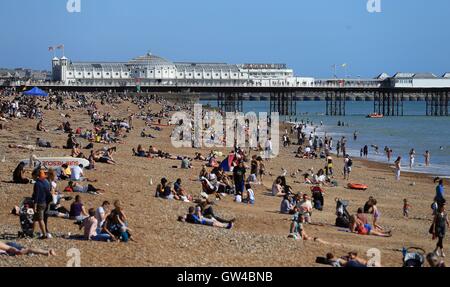 Menschen genießen Sie die Sonne am Strand von Brighton, East Sussex. Stockfoto