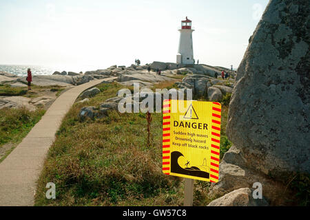 Ein Schild an der Peggy Point Lighthouse Warnung Menschen über die Gefahren des Seins zu nahe an das Meer auf den Felsen Stockfoto