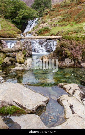 Alte steinerne Fußgängerbrücke über klare Wasser des Afon Cwm Llançà River in der Nähe von watkin Pfad in Snowdonia National Park (Eryri). Bethania, Gwynedd North Wales UK Stockfoto