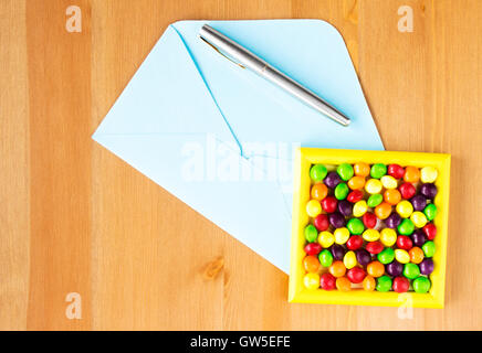Bunte Bonbons Frame, offene blau umhüllen und Stift auf dem Tisch. Kopieren Sie Raum. Flach zu legen. Ansicht von oben Stockfoto