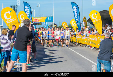 Start von einem Sponsorenlauf zeigt Läufer und Fotografen. Stockfoto