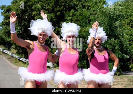 Drei Drag-Queens in rosa Tutus gekleidet und weißen Kopfschmuck vorbereiten für einen Karnevalsumzug in Provincetown, MA, USA Stockfoto