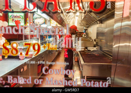 Ein Koch bereitet Steaks auf dem Grill im Fenster des TADS gebratene Steaks in Midtown Manhattan in New York am Dienstag, 6. September 2016. 1957 gegründet, die ikonische Kette ist Teil der Riese Restaurants und dieser Ort ist der einzige links in New York. (© Richard B. Levine) Stockfoto