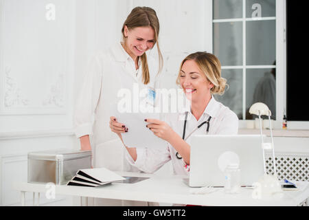 Arzt und Krankenschwester Blick auf Docments in Arztpraxis Stockfoto