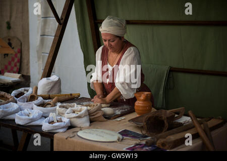 Ein traditioneller Bäcker kneten Teig an einem Marktstand beim Mittelalterfest "Macia" in Spilimbergo, Norditalien. Stockfoto