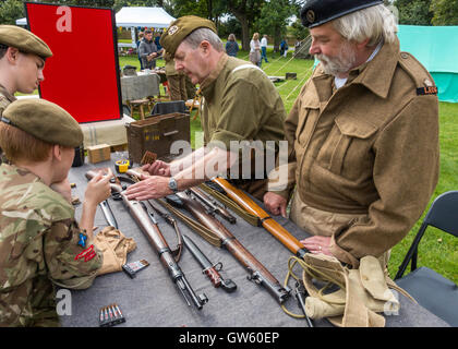 Ein 40er Jahre Heritage Day mit alten Soldaten zeigen, wie man eine Gewehr, Armee-jüngstere Söhne laden Stockfoto