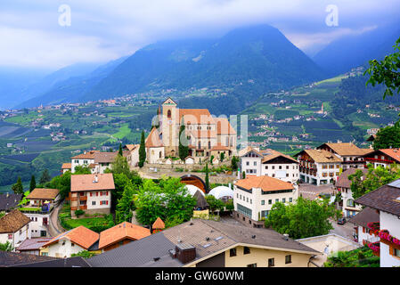 Traditionelle alpine Dorf mit Holzhäusern und roten Ziegeldächern Schenna von Meran in Südtirol, Italien Stockfoto