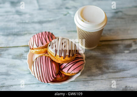 Verglaste Cookies in der Nähe von einer Tasse. Stockfoto