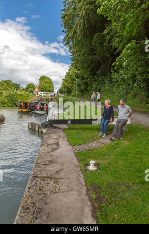 Bunte Lastkähne auf der Durchreise eine der 16 sperrt Caen Hill auf die Kennet & Avon Kanal nr Devizes, Wiltshire, England, UK Stockfoto