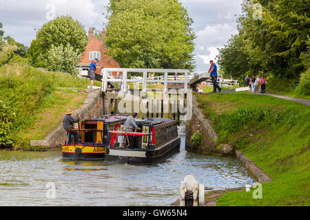 Bunte Lastkähne, die Eingabe eines der 16 sperrt Caen Hill auf die Kennet & Avon Kanal nr Devizes, Wiltshire, England, UK Stockfoto