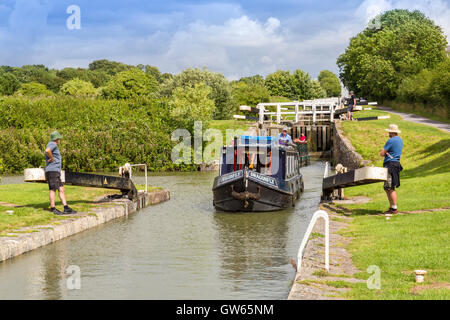 Bunte Lastkähne, die Eingabe eines der 16 sperrt Caen Hill auf die Kennet & Avon Kanal nr Devizes, Wiltshire, England, UK Stockfoto