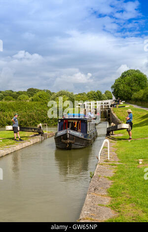 Bunte Lastkähne, die Eingabe eines der 16 sperrt Caen Hill auf die Kennet & Avon Kanal nr Devizes, Wiltshire, England, UK Stockfoto