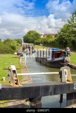 Bunte Lastkähne, die Eingabe eines der 16 sperrt Caen Hill auf die Kennet & Avon Kanal nr Devizes, Wiltshire, England, UK Stockfoto