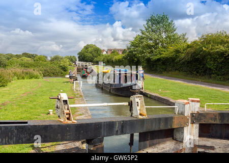 Bunte Lastkähne, die Eingabe eines der 16 sperrt Caen Hill auf die Kennet & Avon Kanal nr Devizes, Wiltshire, England, UK Stockfoto