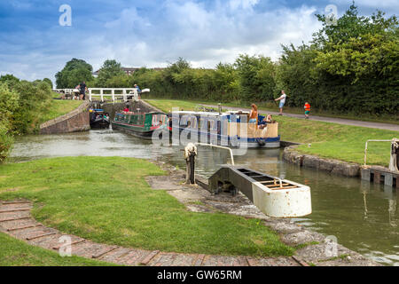 Bunte Lastkähne auf der Durchreise eine der 16 sperrt Caen Hill auf die Kennet & Avon Kanal nr Devizes, Wiltshire, England, UK Stockfoto