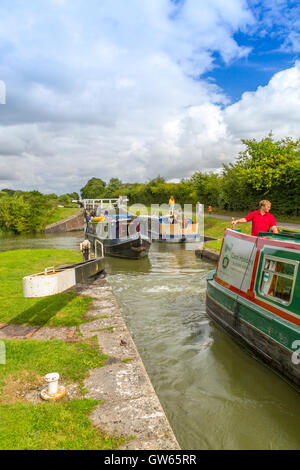 Bunte Lastkähne, die Eingabe eines der 16 sperrt Caen Hill auf die Kennet & Avon Kanal nr Devizes, Wiltshire, England, UK Stockfoto