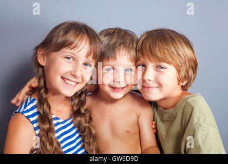 Süße Schwester umarmt jüngeren Brüder Stockfoto