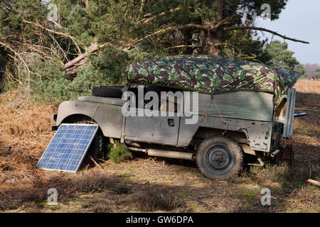 Land Rover geparkt im Wald mit Solarzellen Strom erzeugen Stockfoto