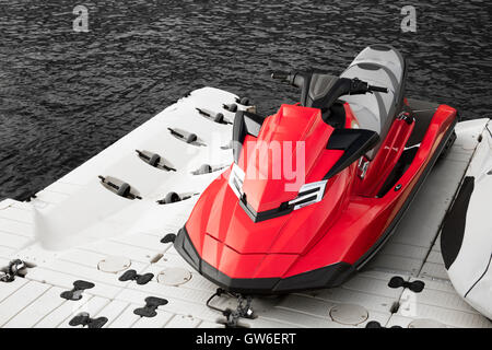 Roter Jet-Ski, parkte direkt am Meer in schwarz / weiß-Szene Stockfoto