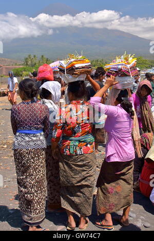 Frauen gekleidet schön bei einer balinesischen Feuerbestattung Zeremonie am Strand in Amed, Bali, Indonesien Stockfoto