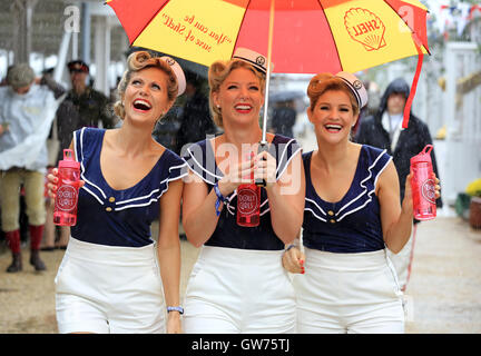 Die Dolly-Mädchen (l-R Hannah Woolley, Helen Patching, Katy Osborne, aus London), ein enger Harmonie Vintage Trio, in Vintage Seemann Outfits gekleidet sind abgebildet, während die Nässe beim Goodwood Revival.   Das Goodwood Revival ist eine dreitägige Festival jedes Jahr im September im Goodwood Circuit seit 1998 für die Arten von Straßenrennen Autos und Motorrad, die in der Schaltung original Zeitraum teilgenommen haben würde – 1948 – 1966. Stockfoto