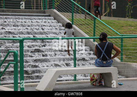 Kinder haben Spaß im Wasserkaskaden von Madureira Park. Der Madureira Park ist der drittgrößte Freizeitbereich der Stadt Rio De Janeiro. Die Website, die an den Ufern der Eisenbahnlinie gebaut ist, die mehrere Vorstadtnachbarschaften von Rio durchquert und ist ein Armenviertel der Stadt. Die Website wurde vor kurzem erweitert und gewonnene neue Dienste wie Tennisplätze für kostenlose Nutzung, neue Radwege und neue Bereiche der Freizeit- und Unterhaltungsmöglichkeiten. Vor Ort stellen wir die künstlichen Seen, die in der Form und Farben der Olympischen Ringe und auch der "künstliche Strände", wo Wasserfälle die Freude des Chi machen, gemacht Stockfoto