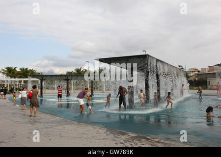 Kinder haben Spaß im Wasserkaskaden von Madureira Park. Der Madureira Park ist der drittgrößte Freizeitbereich der Stadt Rio De Janeiro. Die Website, die an den Ufern der Eisenbahnlinie gebaut ist, die mehrere Vorstadtnachbarschaften von Rio durchquert und ist ein Armenviertel der Stadt. Die Website wurde vor kurzem erweitert und gewonnene neue Dienste wie Tennisplätze für kostenlose Nutzung, neue Radwege und neue Bereiche der Freizeit- und Unterhaltungsmöglichkeiten. Vor Ort stellen wir die künstlichen Seen, die in der Form und Farben der Olympischen Ringe und auch der "künstliche Strände", wo Wasserfälle die Freude des Chi machen, gemacht Stockfoto