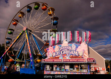 Kirmes in der Mitte mit Riesenrad, Fahrgeschäfte und Essen Stände Stockfoto