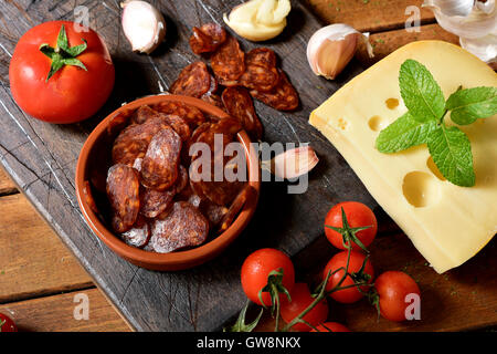 High-Angle Shot eine Steingut-Schale mit einige Scheiben der spanischen Chorizo, eine typisch für Spanien, auf einem rustikalen hölzernen Wurst aus Schweinefleisch Stockfoto