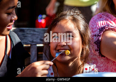 Ein kleines Mädchen essen Chips, Brighton, Sussex, UK Stockfoto