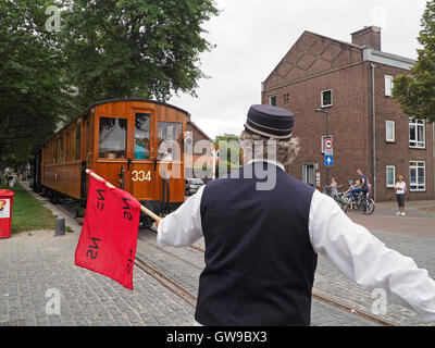 In der Vergangenheit begleitet ein Mann mit einer roten Fahne der Dampfstraßenbahn, um andere Verkehrsteilnehmer an Kreuzungen wie diese in Breda zu warnen.