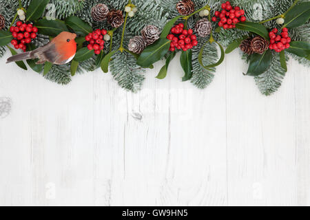 Traditionelle Winter und Weihnachten umrandet mit Robin Dekoration, Flora der Stechpalme, Mistel, Schnee bedeckt, Tanne und Kiefer Stockfoto