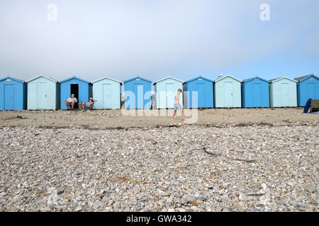 Ein paar entspannende in Liegestühlen im Sommer den Strandhütten am Strand von Charmouth Dorset UK KATHY DEWITT Stockfoto