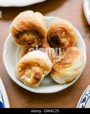 eine kleine weiße Schüssel mit Brot, die hausgemachte ist Stockfoto