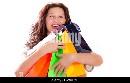 isolierte Aufnahme einer shopping Enthusiasten Reife Frau umarmt bunte Taschen auf weißem Hintergrund Stockfoto