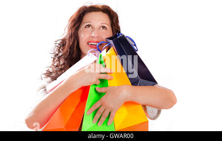 isolierte Schuss von shopping Enthusiasten Reife Frau auf der Suche nach oben, während umarmt bunte Taschen auf weißem Hintergrund Stockfoto