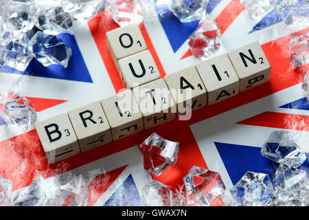 Die Begriffe Großbritannien und Out auf Flagge von Großbritannien, symbolische Foto Austritt, Buchstabenwuerfel Formen sterben Beg bilden Brief Würfel Stockfoto