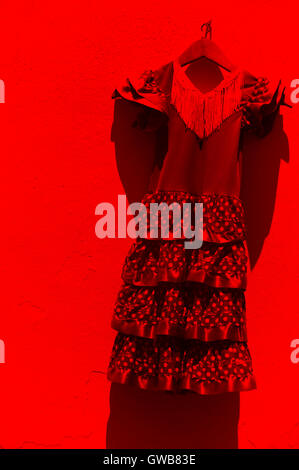 Flamenco-Kleid hängt an einer weißen Wand in Andalusien. Spanien. Vertikal Stockfoto