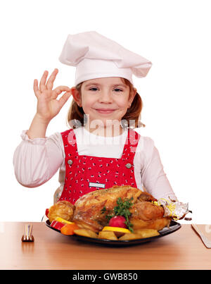 wunderschönes kleines Mädchen Kochen mit gegrilltem Hähnchen Stockfoto