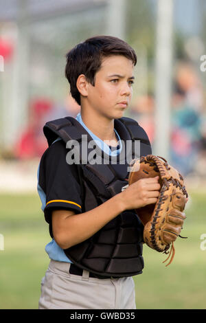 Ein Teenager Baseball-Spieler tragen Catcher Getriebe bei einem Baseball-Spiel in Cairns, Australien Stockfoto