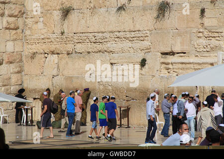 Junge jüdische Jungen zusammen mit anderen Gläubigen beten Mens seitlich des westlichen Klagemauer, auch bekannt als Kotel Stockfoto