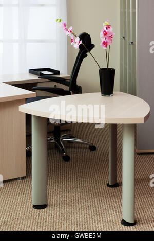 Orchideen auf dem Tisch in einem modernen Büro Stockfoto