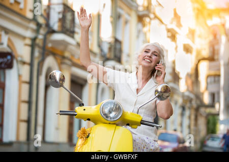 Reife Dame mit Telefon Lächeln auf den Lippen. Stockfoto
